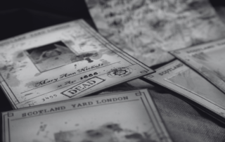 Vintage Scotland Yard case files and handwritten documents spread out on a table.