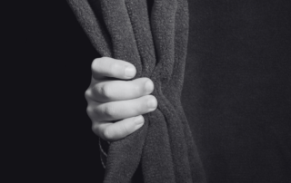 A clenched fist held up against a dark background.