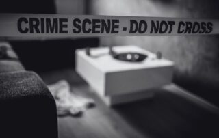 A gift box on a table in front of crime scene tape reading do not cross.