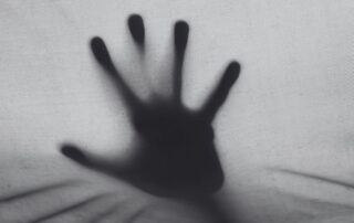 A hand pressed flat against frosted glass from the other side.