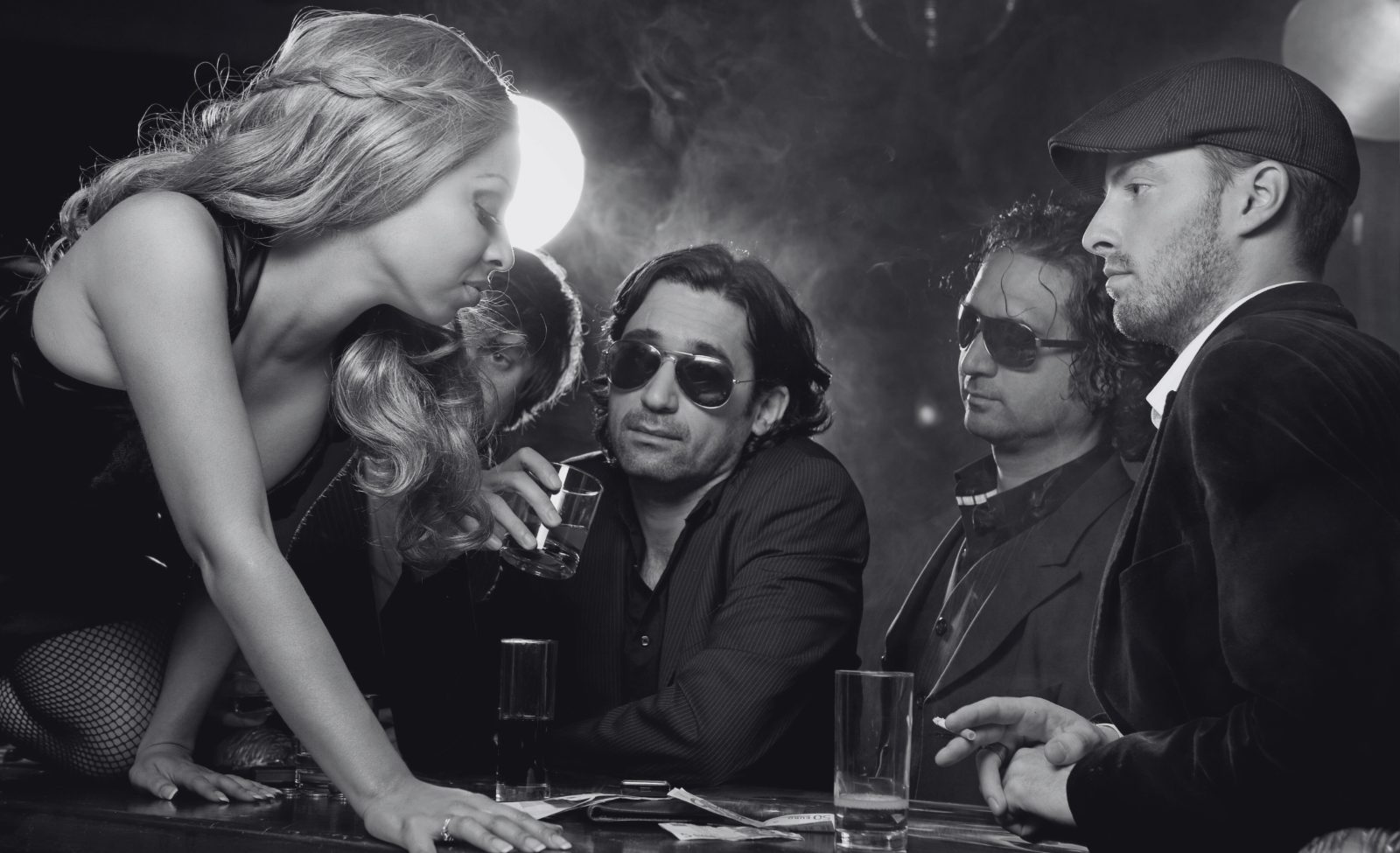 91-4-opt Party guests in sunglasses and evening clothes gathered at a bar.