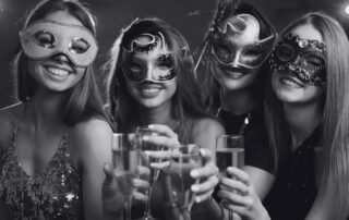 Women in masquerade masks raising champagne glasses together.